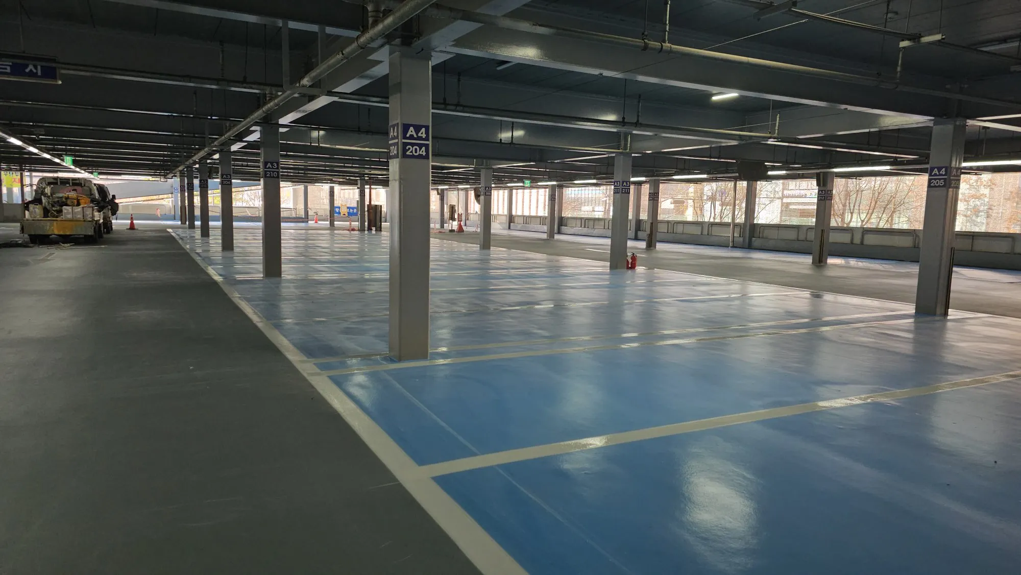 Finished blue polyurea coating with line markings in parking structure — APTECH system final result