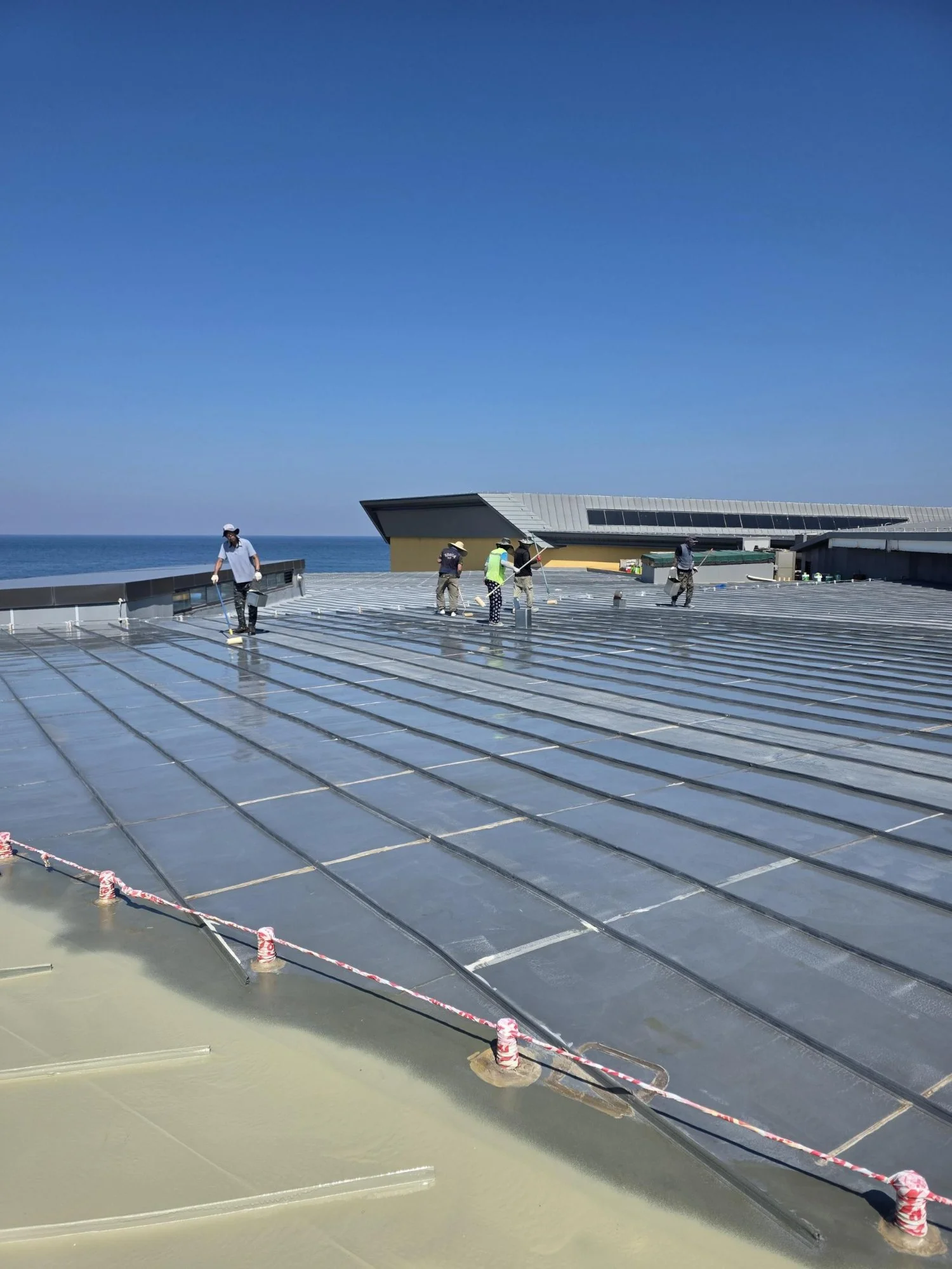 Rooftop waterproofing construction using polyurea spray application